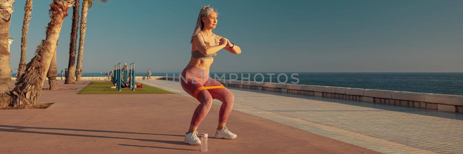 Female exercising on warm day by the coast by Yaroslav_astakhov