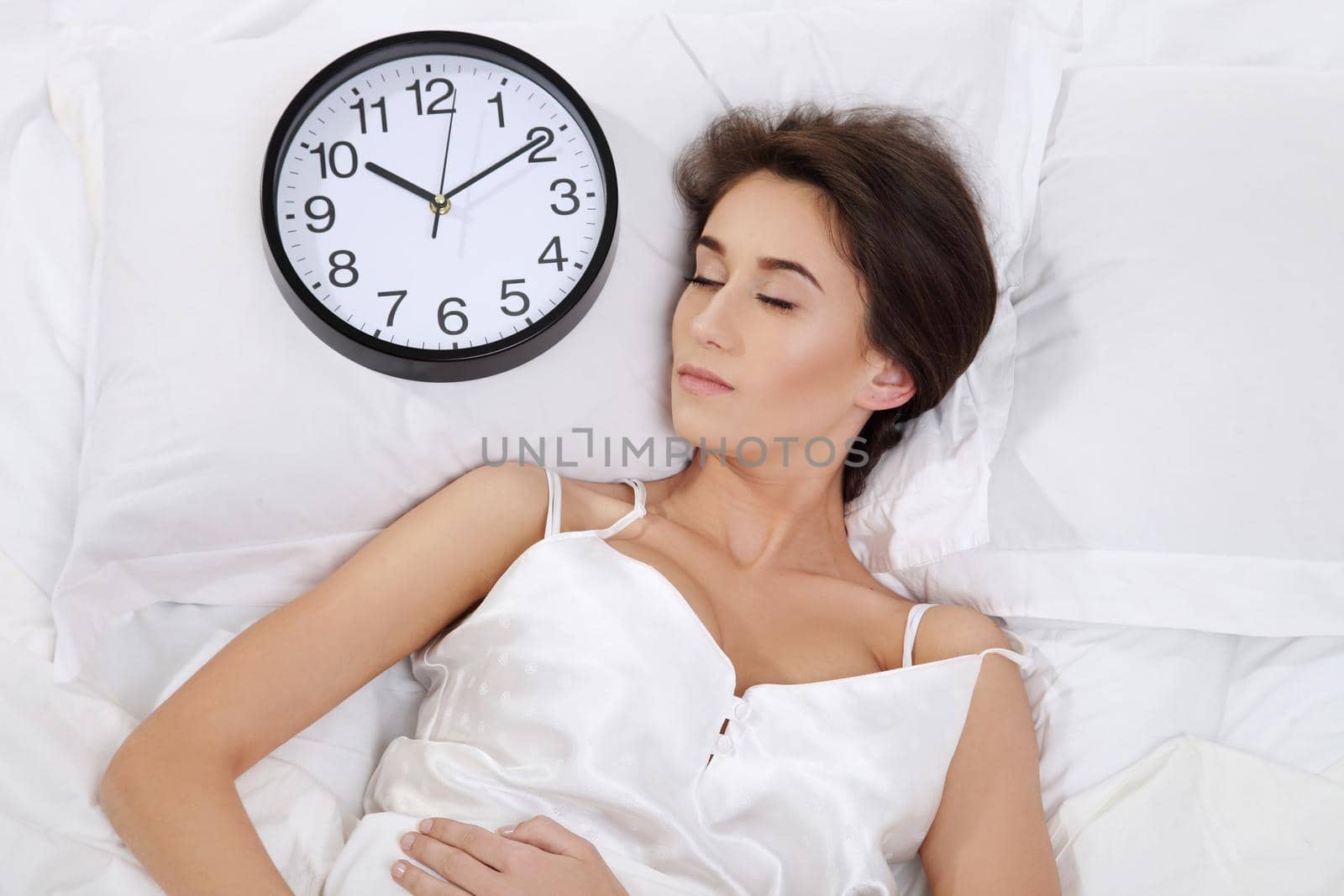 Happy woman waking up and turning off the alarm clock