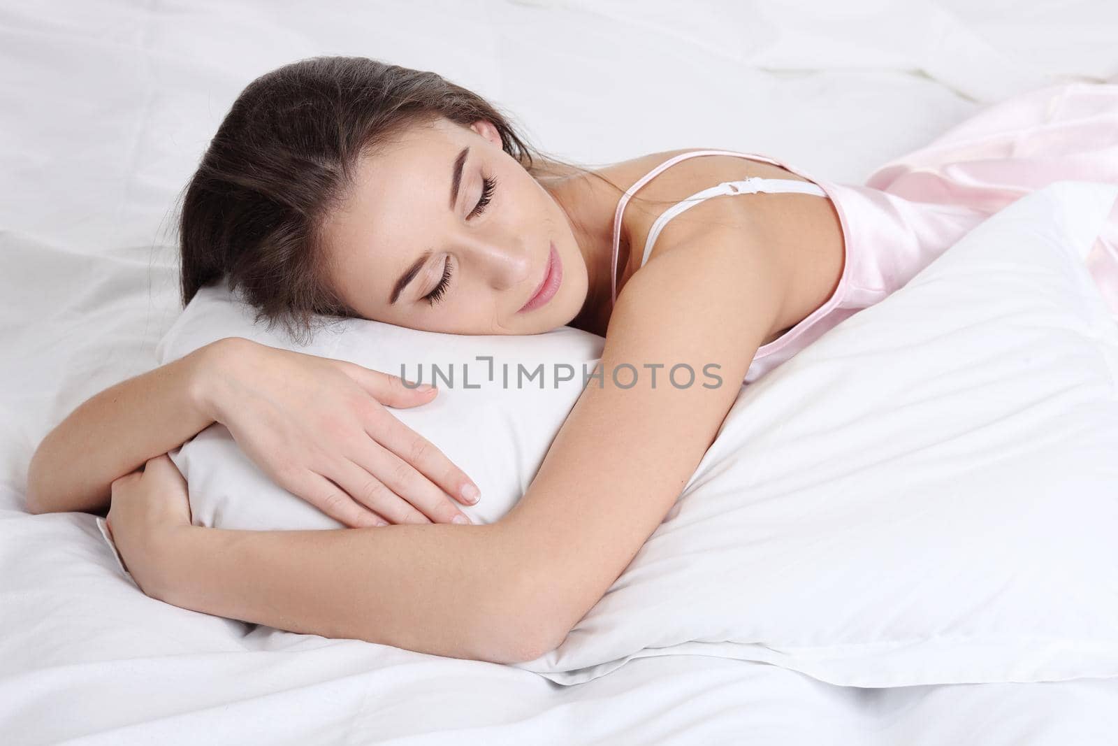 Young beautiful woman waking up in her bed fully rested. Woman in bed after wake up. Healthy lifestyle.