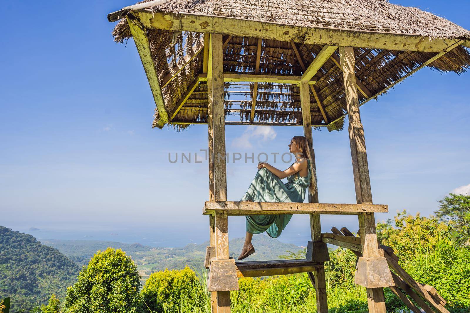 Young woman in traditional balinese gazebo. Bali island.