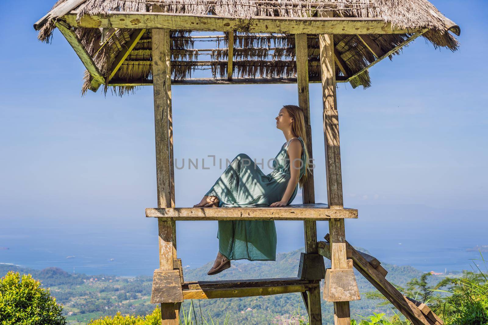 Young woman in traditional balinese gazebo. Bali island by galitskaya