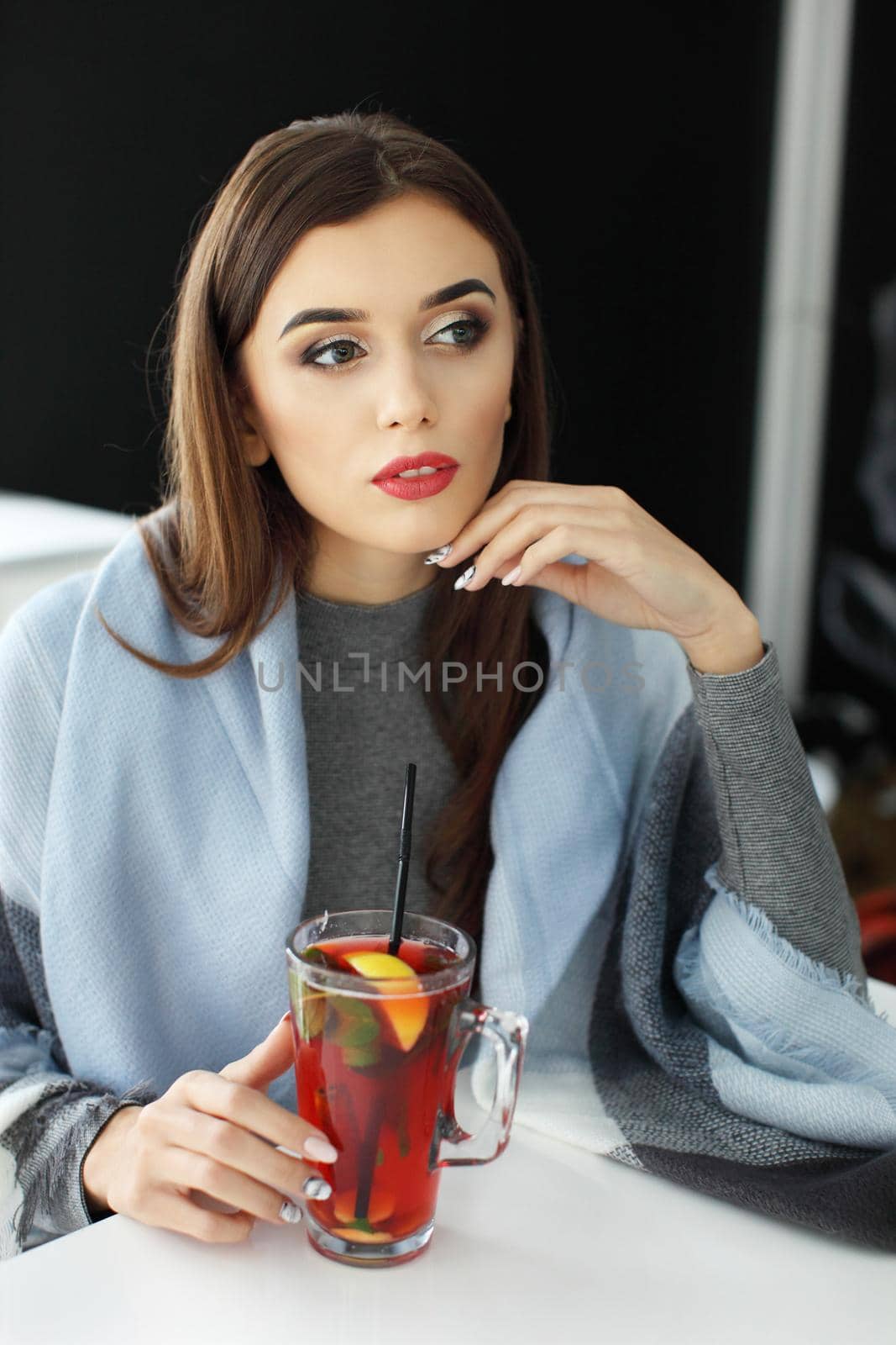young woman holding a cup of hot mint tea or hot lemonade