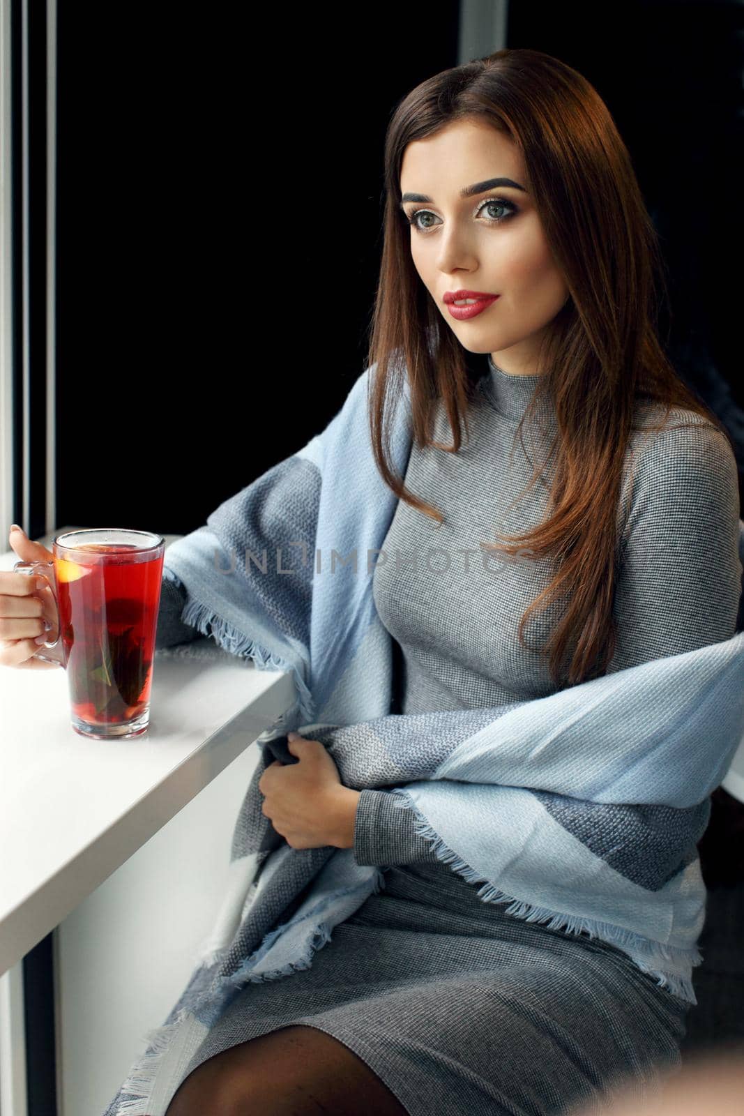 young woman holding a cup of hot mint tea or hot lemonade