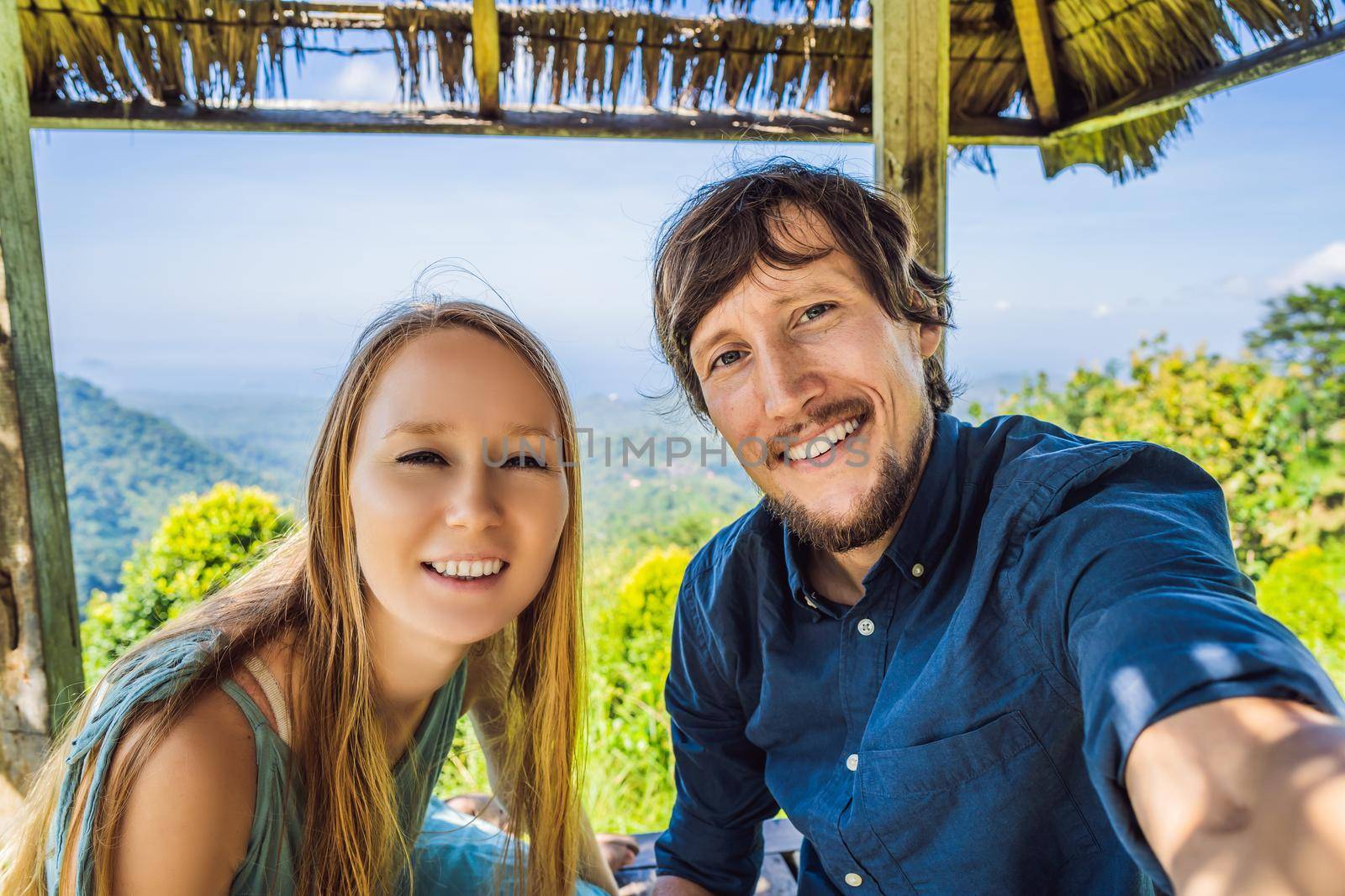 Young man and woman in traditional balinese gazebo. Bali island.