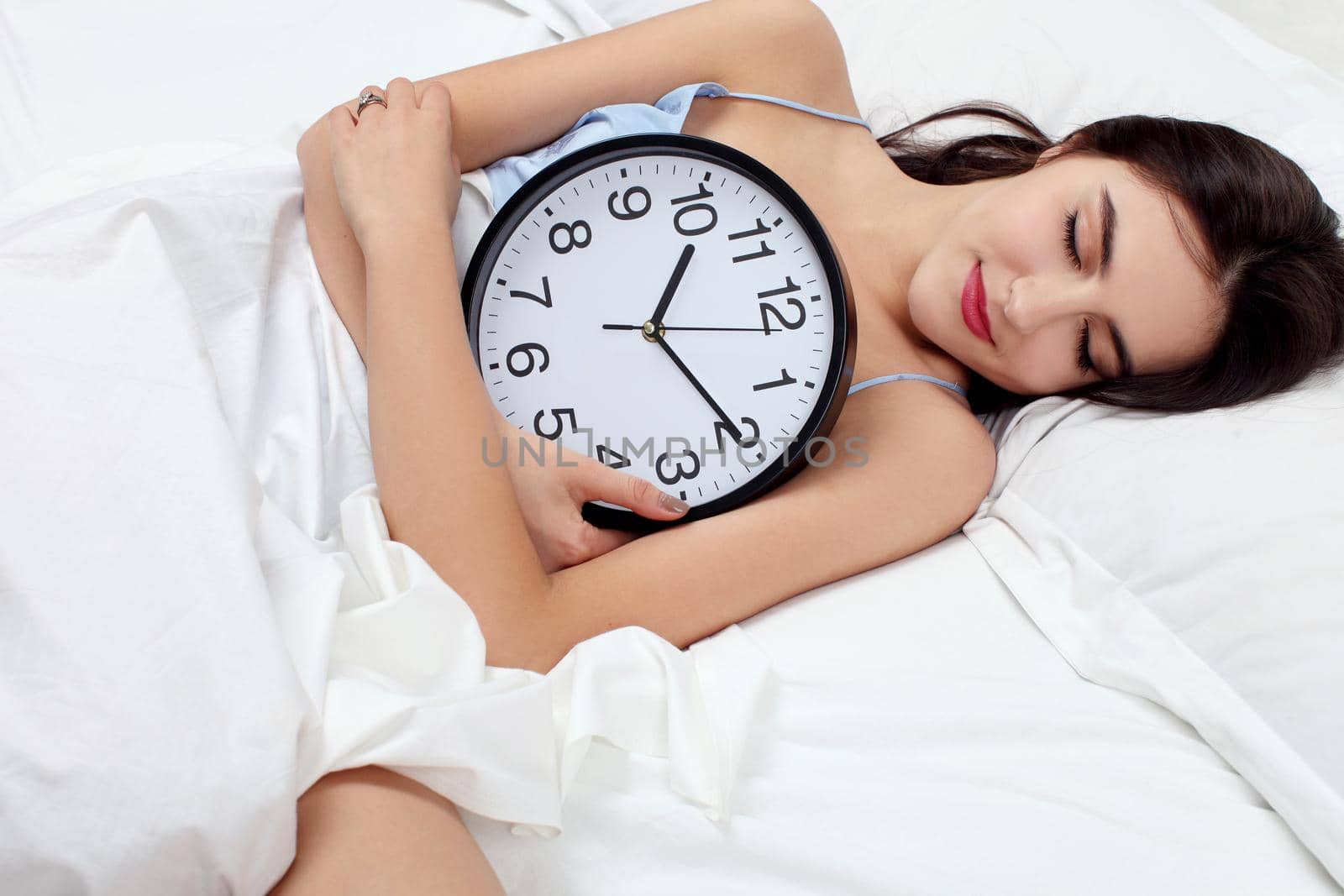 Young beautiful woman with alarm clock
