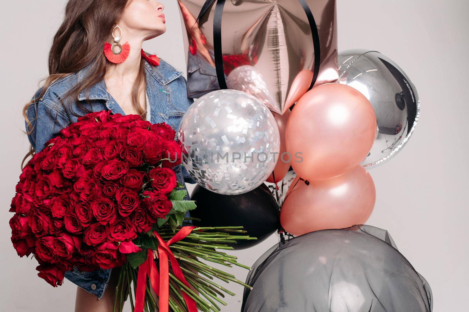 Gorgeous stylish brunette woman with bunch of air balloons and red roses. by StudioLucky