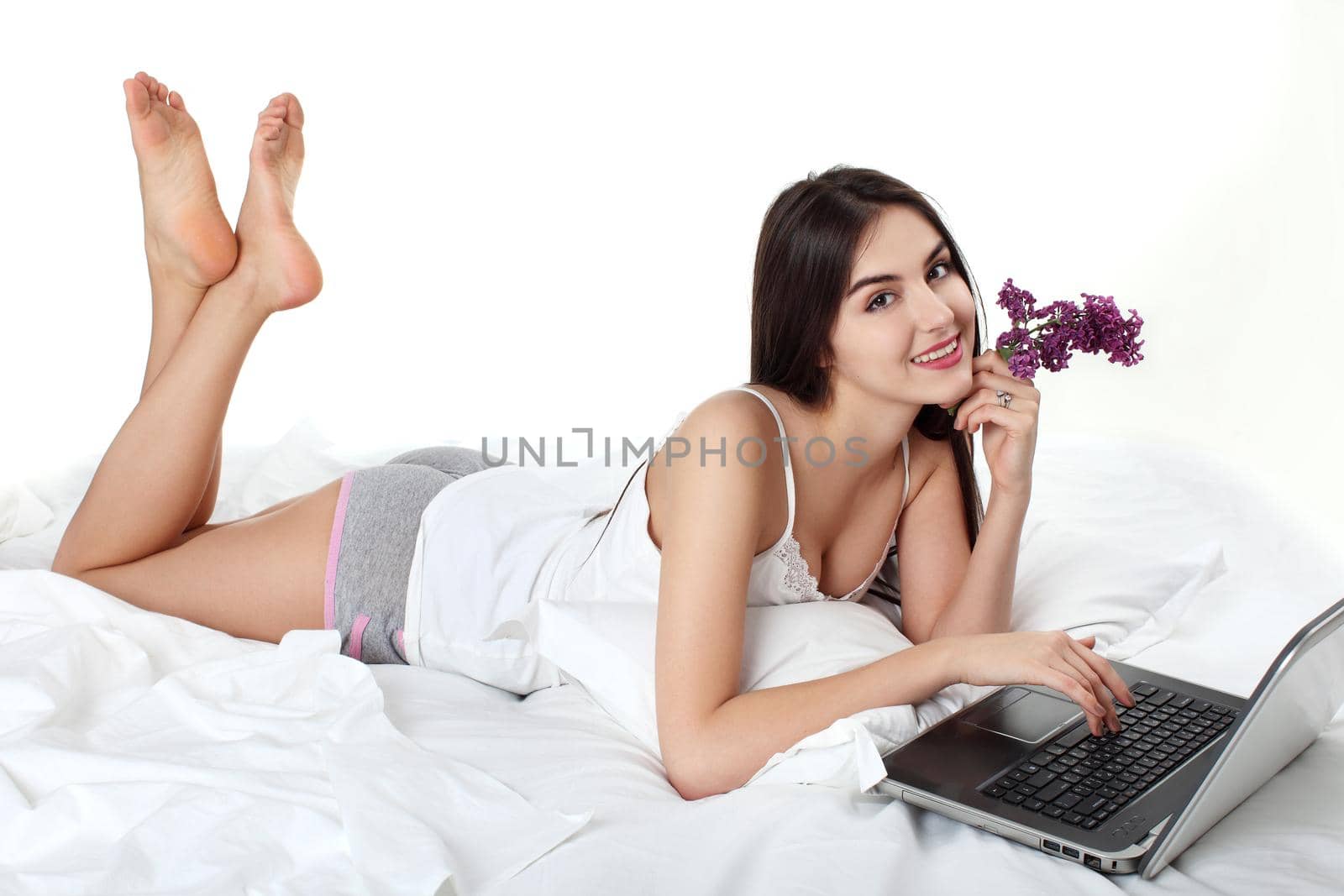 Attractive female relaxing with her laptop while on bed