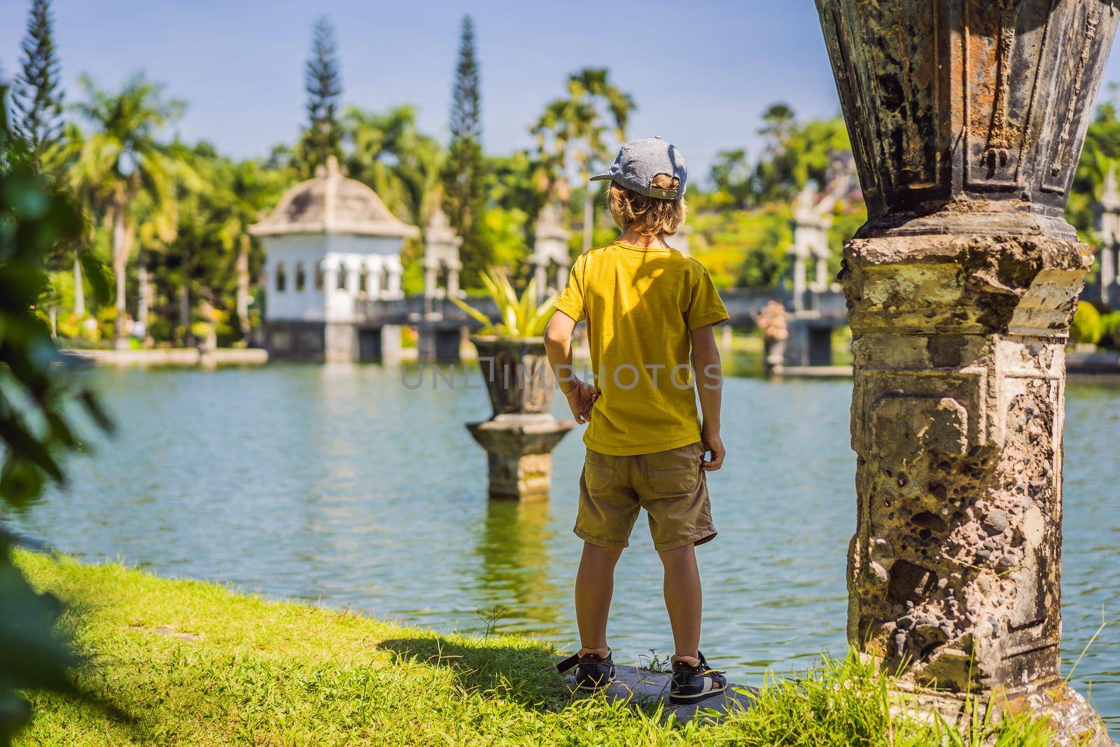 Young boy in Water Palace Soekasada Taman Ujung Ruins on Bali Island in Indonesia. Amazing old architecture. Travel and holidays background. Traveling with kids concept. Kids Friendly places.