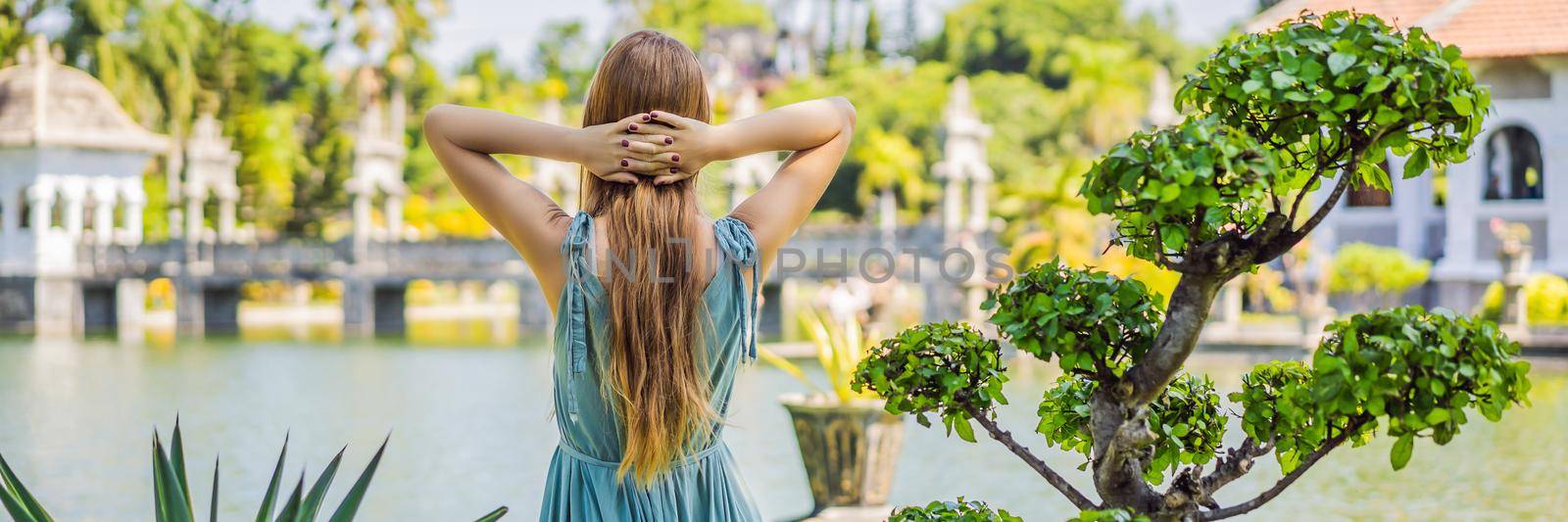 Young woman in dress in Water Palace Soekasada Taman Ujung Ruins on Bali Island in Indonesia. Amazing old architecture. Travel and holidays background. BANNER, LONG FORMAT