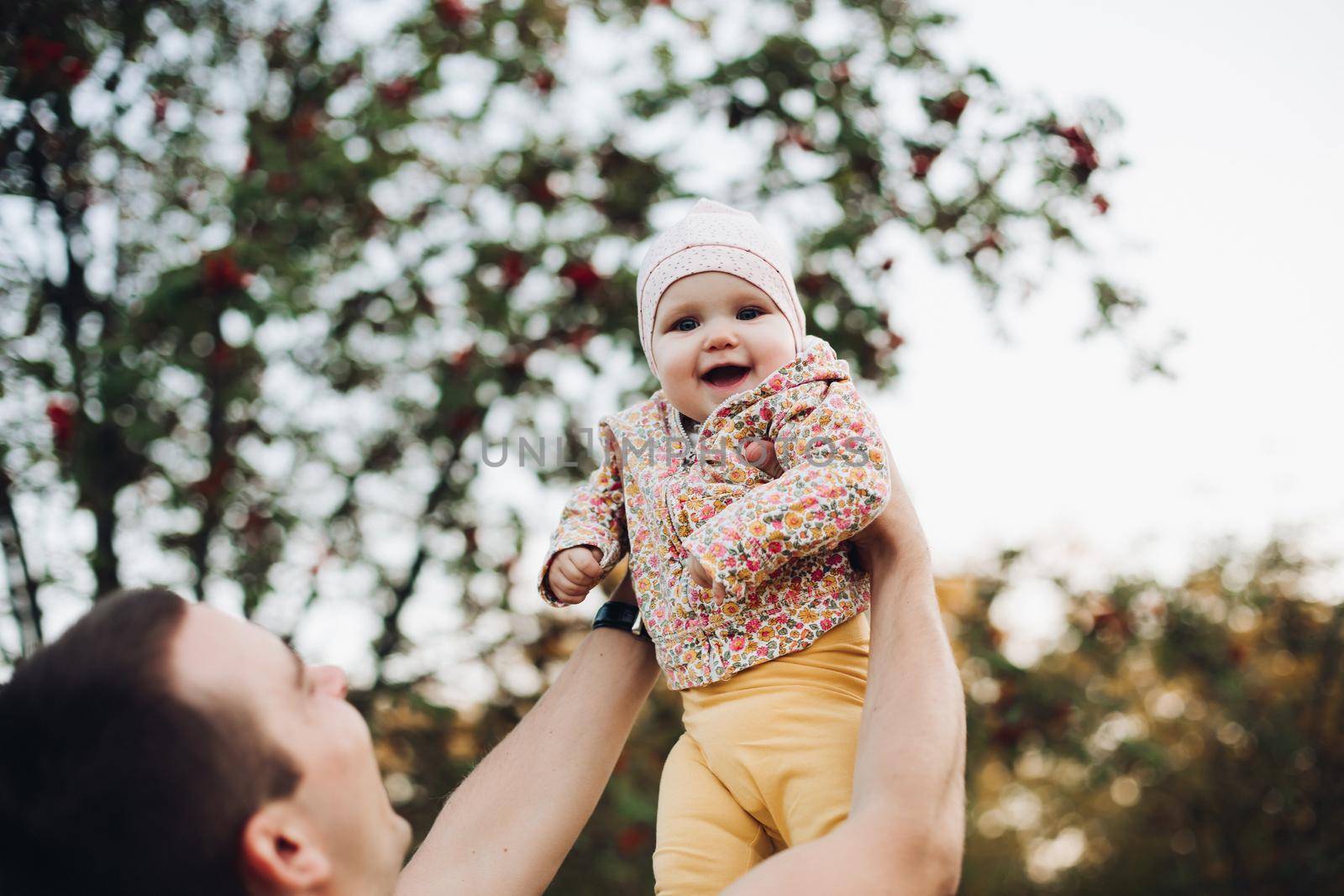 Father and daughter walking in the park in autumn, portrait. Dad and daughter, family concept. A little girl in fother's arms by StudioLucky