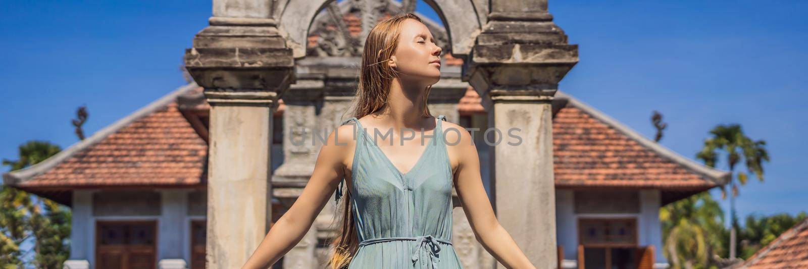 Young woman in dress in Water Palace Soekasada Taman Ujung Ruins on Bali Island in Indonesia. Amazing old architecture. Travel and holidays background BANNER, LONG FORMAT by galitskaya