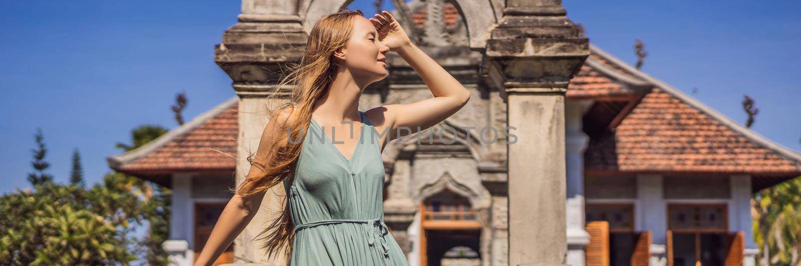 Young woman in dress in Water Palace Soekasada Taman Ujung Ruins on Bali Island in Indonesia. Amazing old architecture. Travel and holidays background BANNER, LONG FORMAT by galitskaya