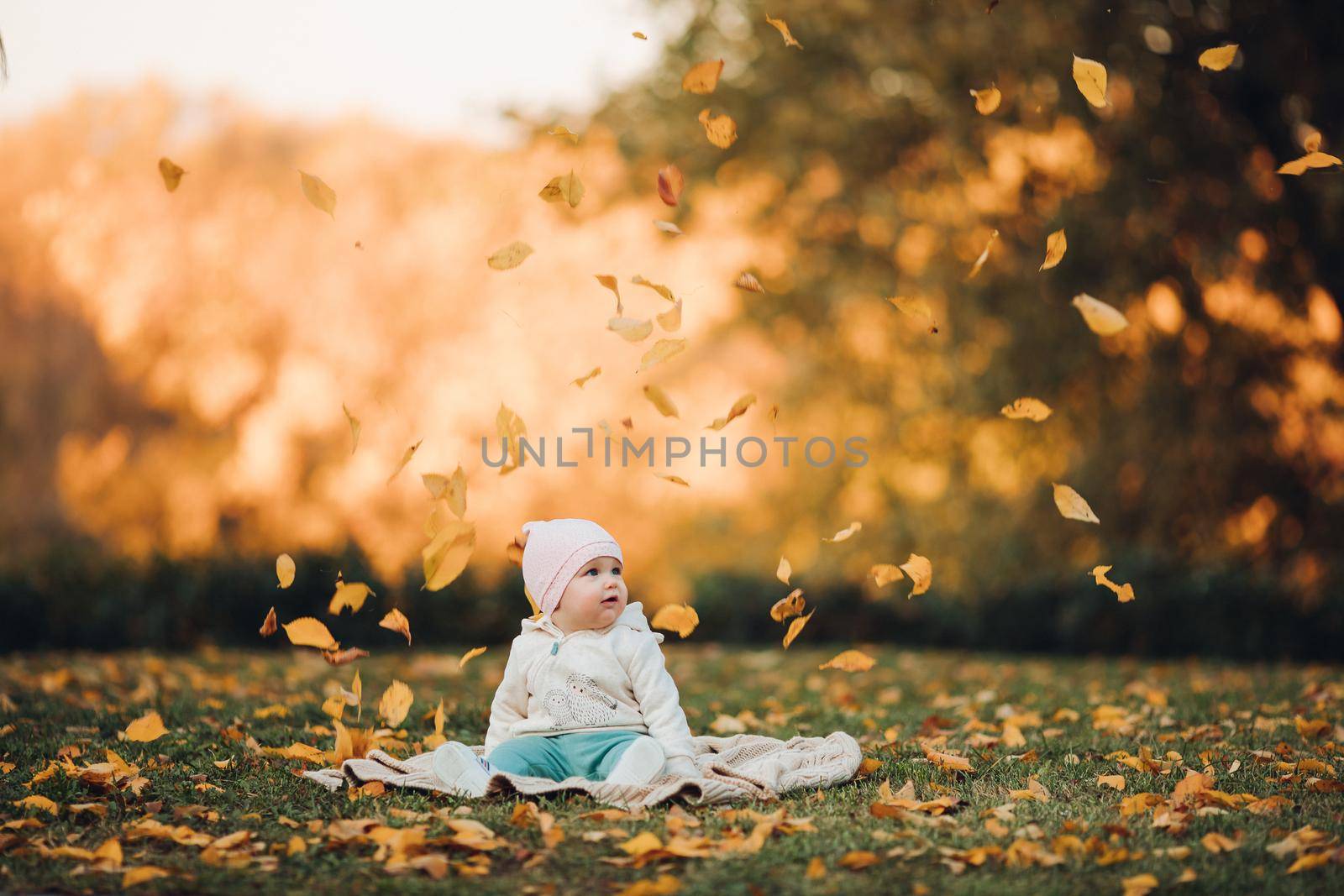 A little girl child in the autumn park smiles, spends time. Beautiful autumn background