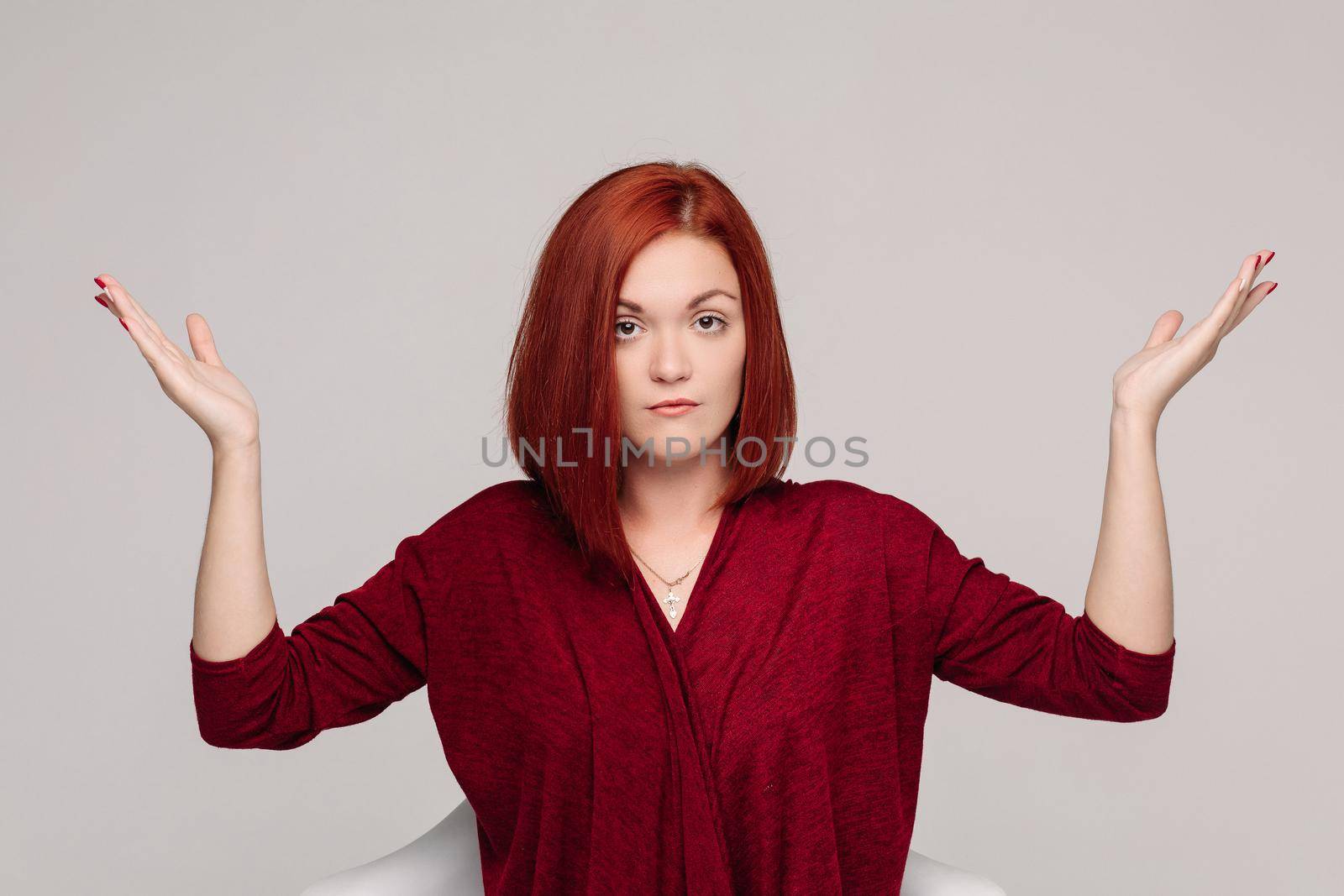 Front view of beautiful business woman wearing in red with short haircut having disregard and passive emotion, looking at camera. Girl do not understanding why and looking frustrated.