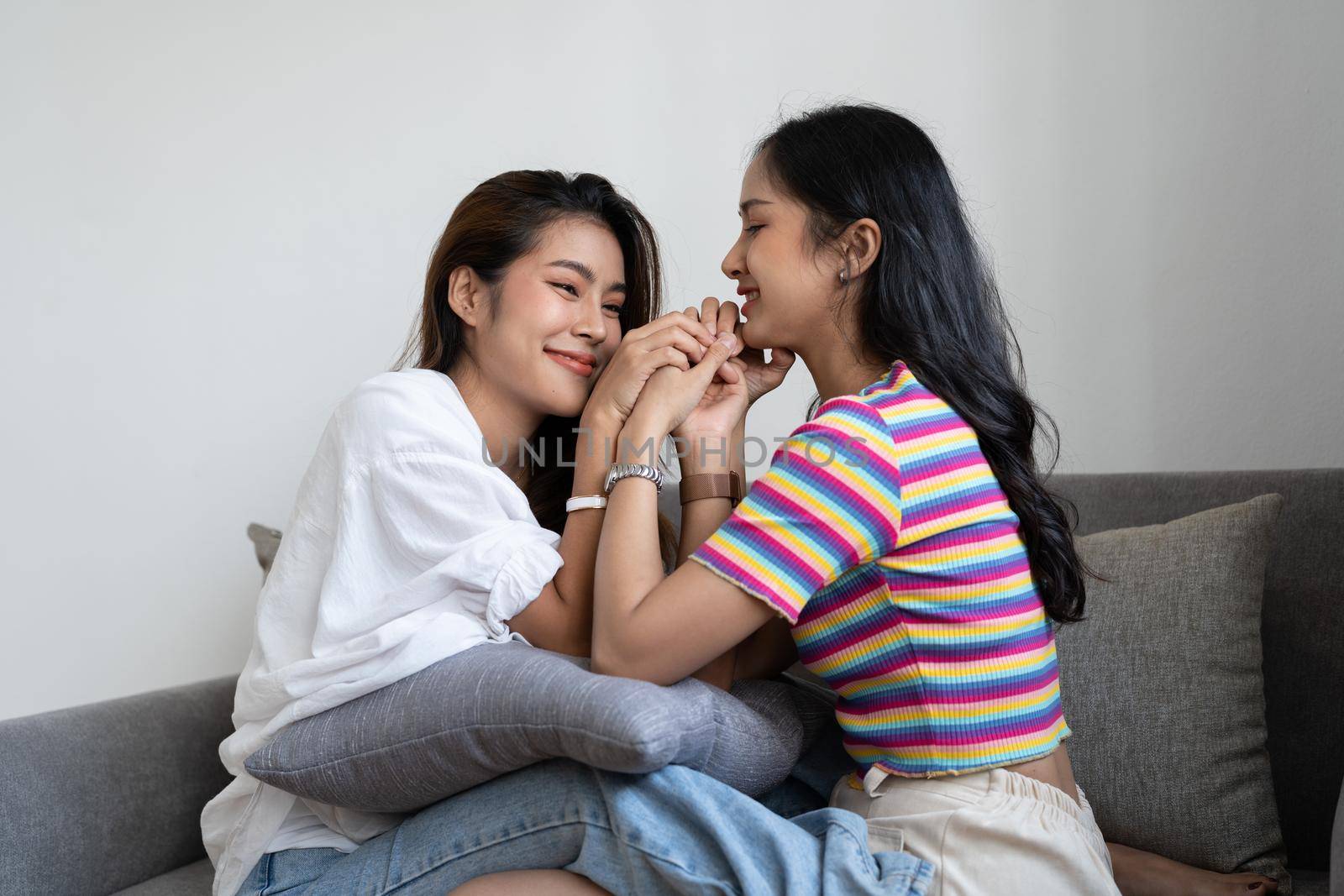 Happy lesbian, pleasure asian young two women, girl gay or close friend, couple love moment spending good time together on sofa at home. Activity of leisure, relax