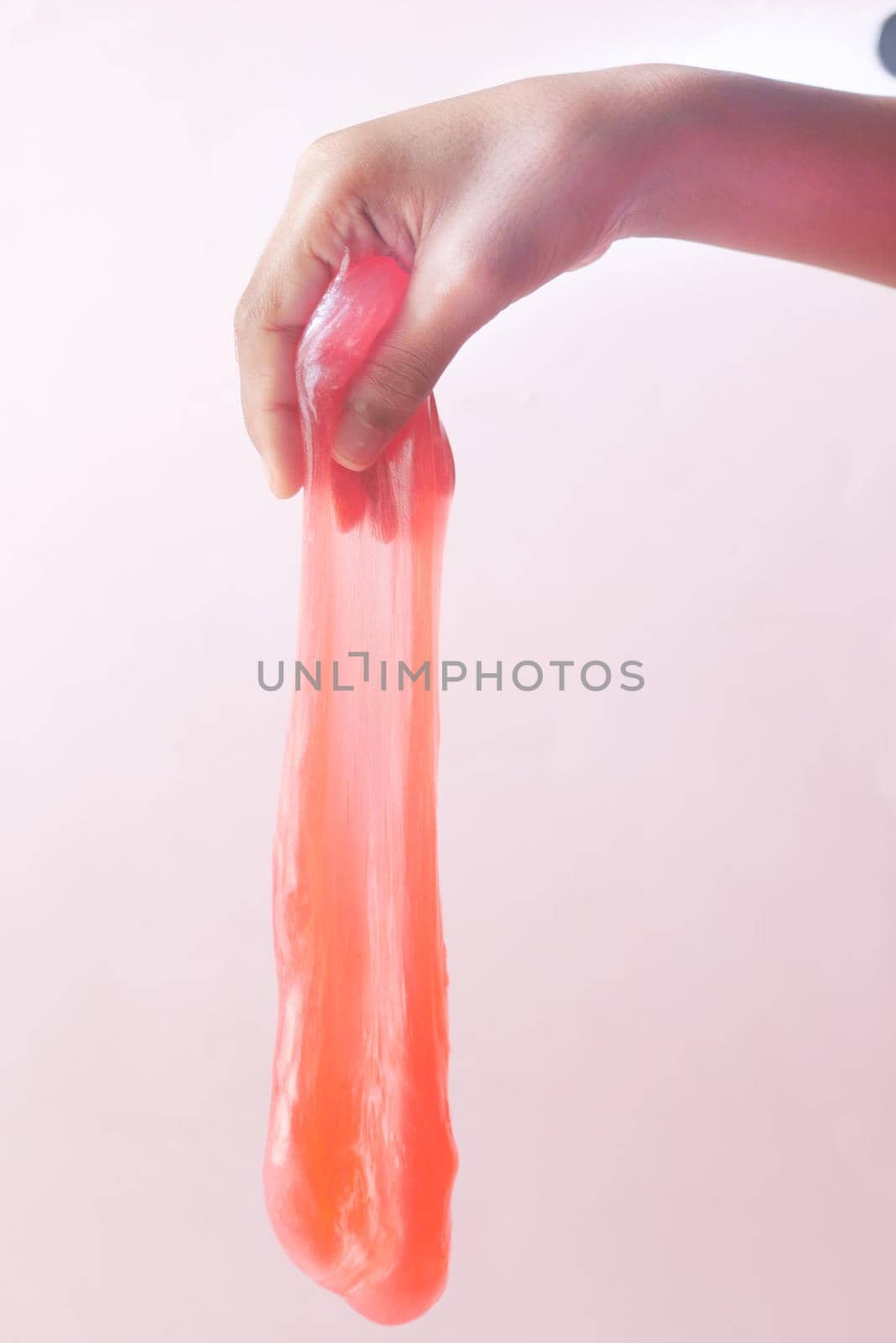 child Hand holding pink color slime .