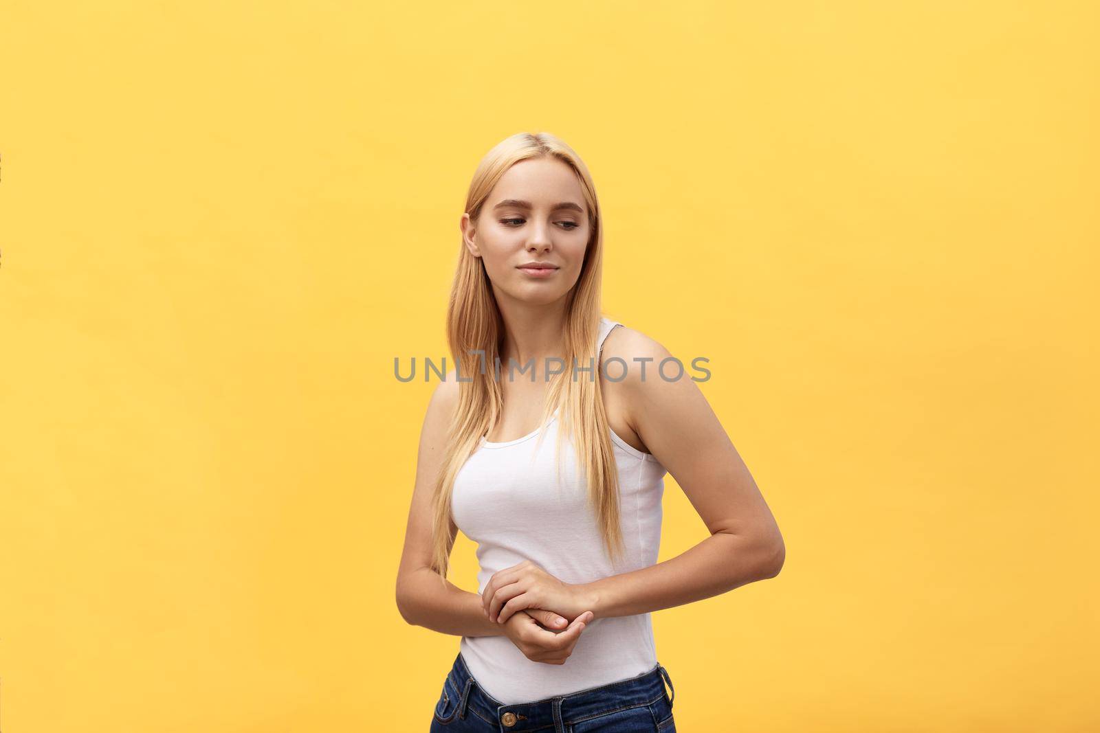 Portrait of happy beautiful young woman smiling looking at camera over yellow background. by Benzoix