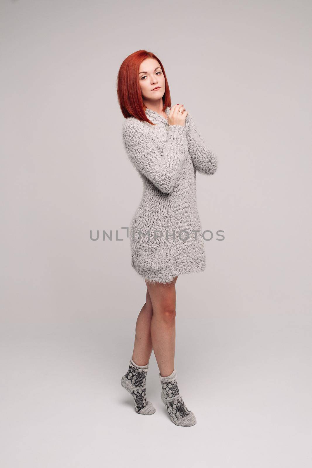 Sensuality red haired girl wearing gray knit sweater and warm socks. by StudioLucky