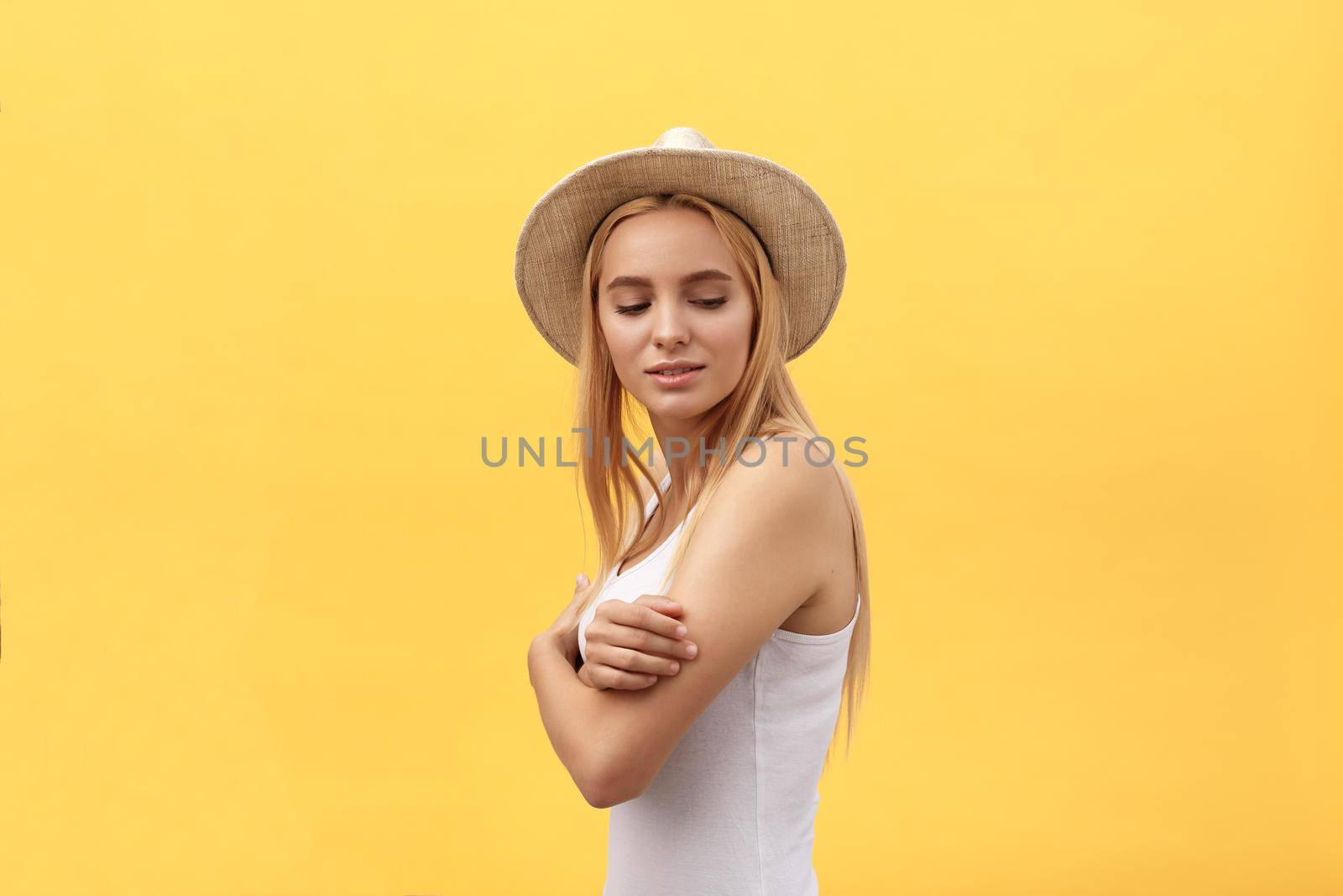 Laughing woman with crossed arms looking at the camera over yellow background.