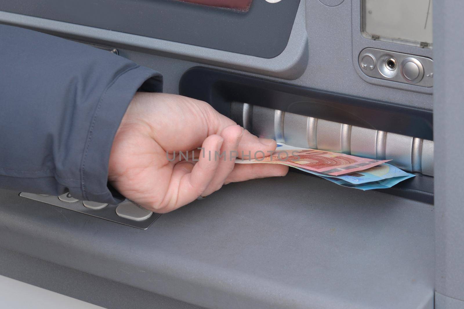 Close-up of hand of man to withdraw money from an ATM