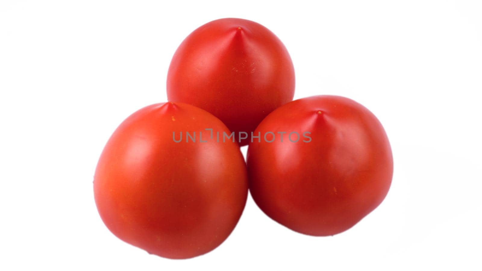 Three whole red tomatoes on a white background in isolation