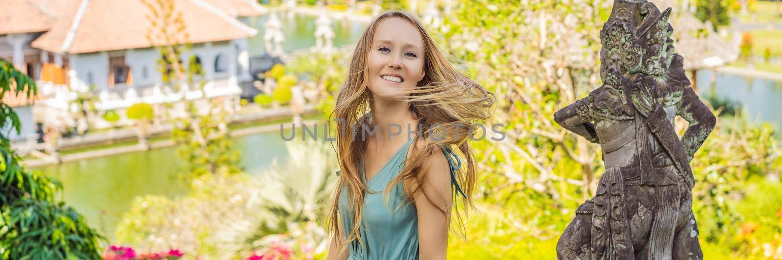 Young woman in dress in Water Palace Soekasada Taman Ujung Ruins on Bali Island in Indonesia. Amazing old architecture. Travel and holidays background BANNER, LONG FORMAT by galitskaya