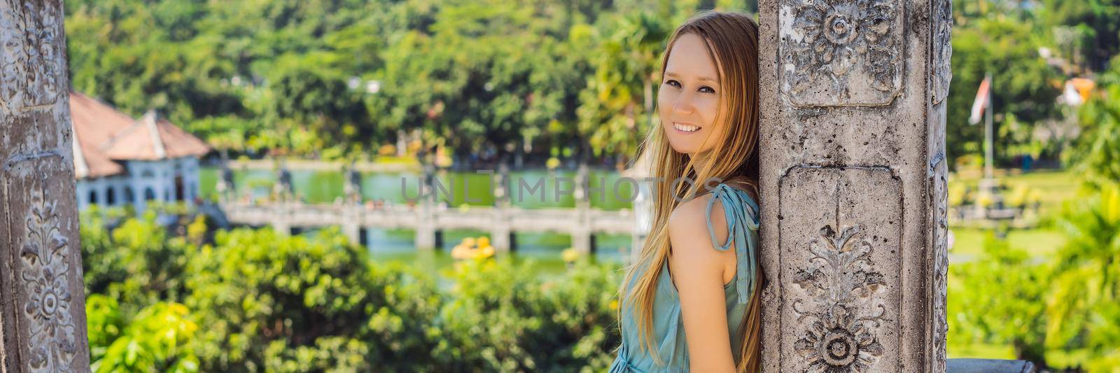 Young woman in dress in Water Palace Soekasada Taman Ujung Ruins on Bali Island in Indonesia. Amazing old architecture. Travel and holidays background. BANNER, LONG FORMAT