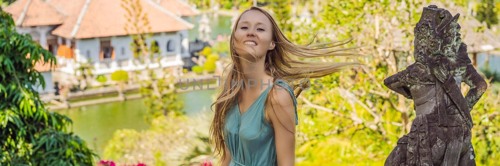 Young woman in dress in Water Palace Soekasada Taman Ujung Ruins on Bali Island in Indonesia. Amazing old architecture. Travel and holidays background BANNER, LONG FORMAT by galitskaya