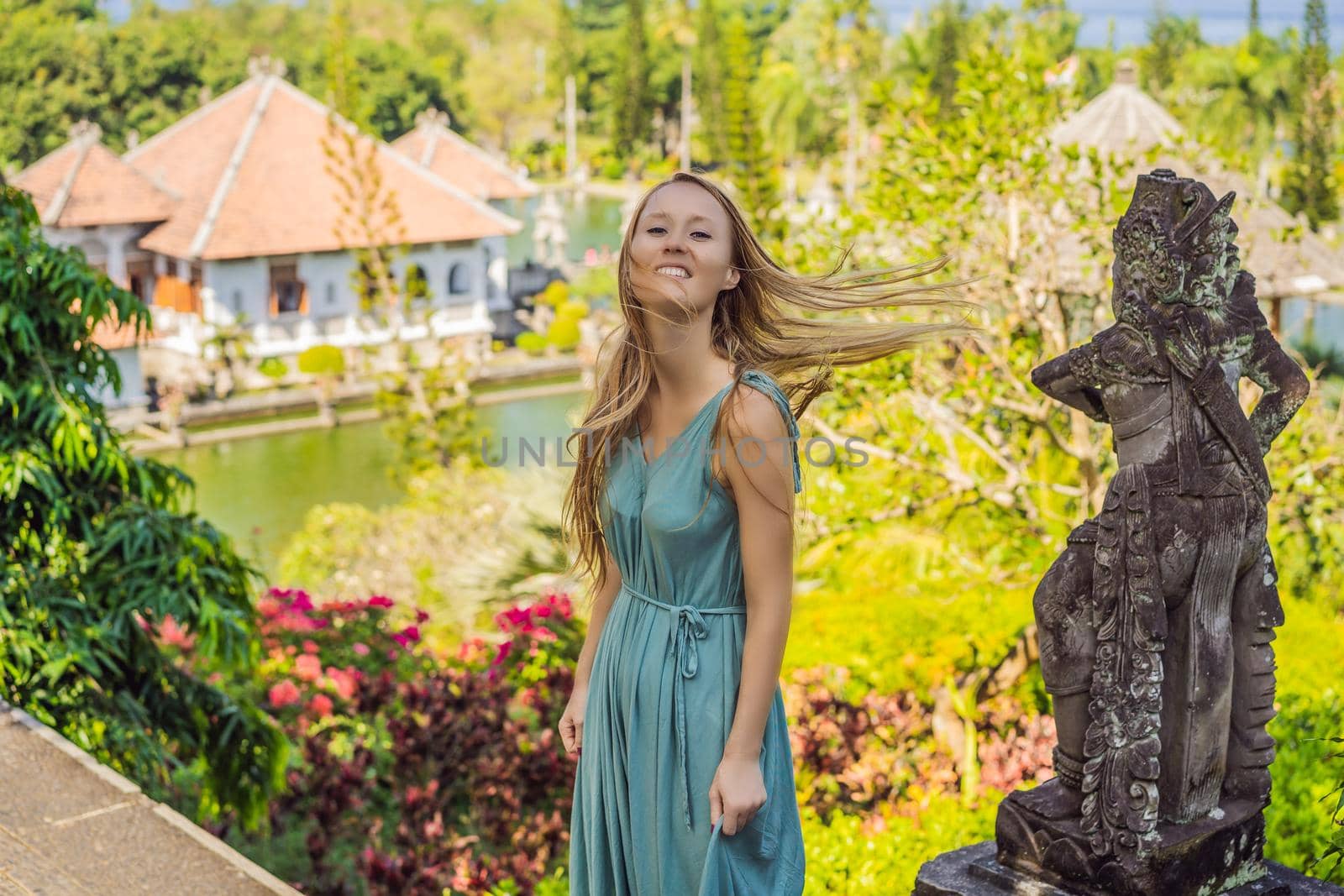 Young woman in dress in Water Palace Soekasada Taman Ujung Ruins on Bali Island in Indonesia. Amazing old architecture. Travel and holidays background.