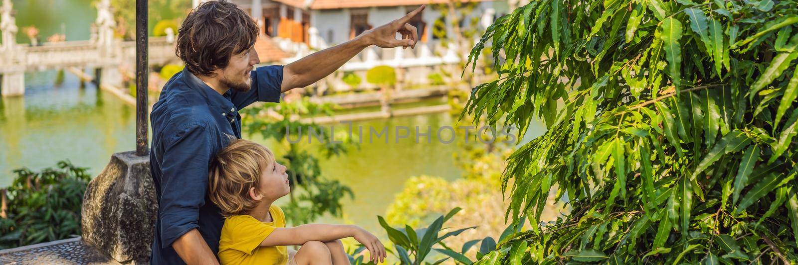 Dad and son in Water Palace Soekasada Taman Ujung Ruins on Bali Island in Indonesia. Amazing old architecture. Travel and holidays background. Traveling with kids concept. Kids Friendly places. BANNER, LONG FORMAT