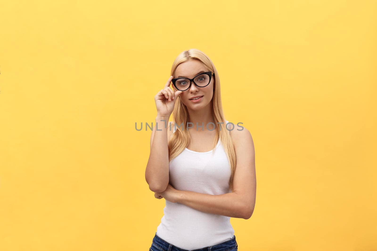 Happy stylish modern woman with modern shaped sunglasses laughing looking at you camera isolated on yellow background. Happiness concept.