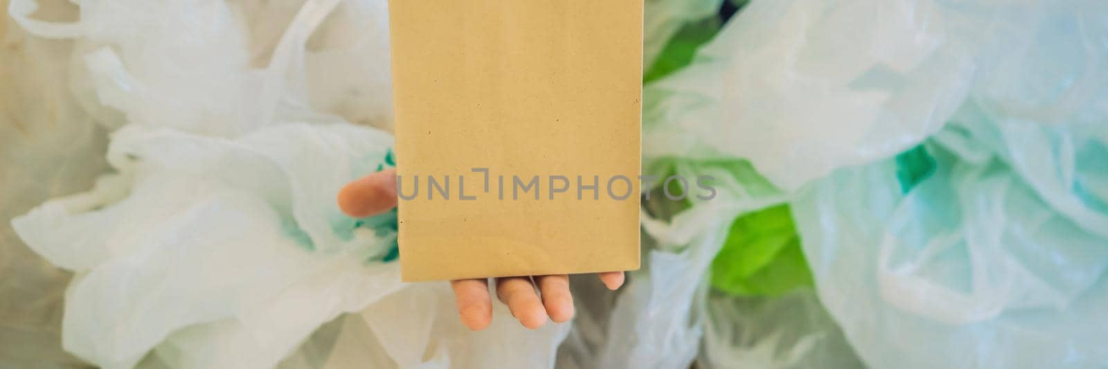 Paper bag amid a pile of plastic bags. Zero waste concept. The concept of World Environment Day. BANNER, LONG FORMAT