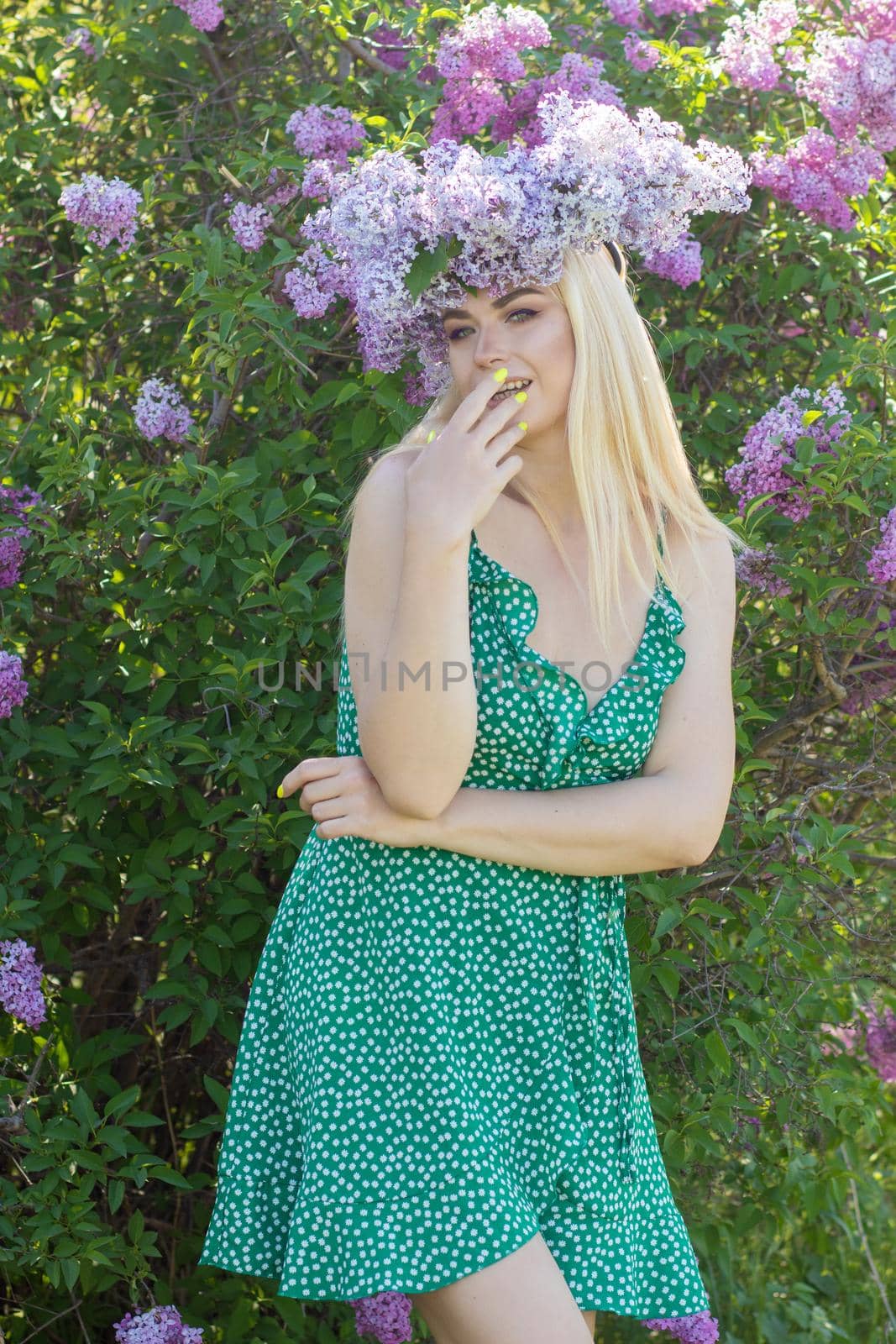 Beautiful woman in lilac Garden. Girl with lilac wreath in springtime. Gardening. Soft focus