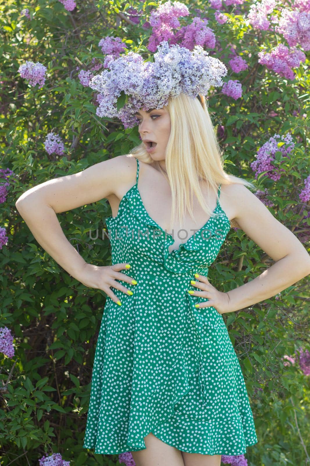 Beautiful woman in lilac Garden. Girl with lilac wreath in springtime. Gardening. Soft focus