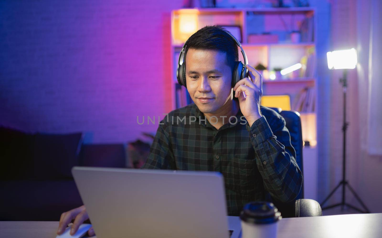 Asian influencer man smile youtuber live streaming or working conferrence with laptop and wearing headphone. Asian man teaching online. by Wmpix