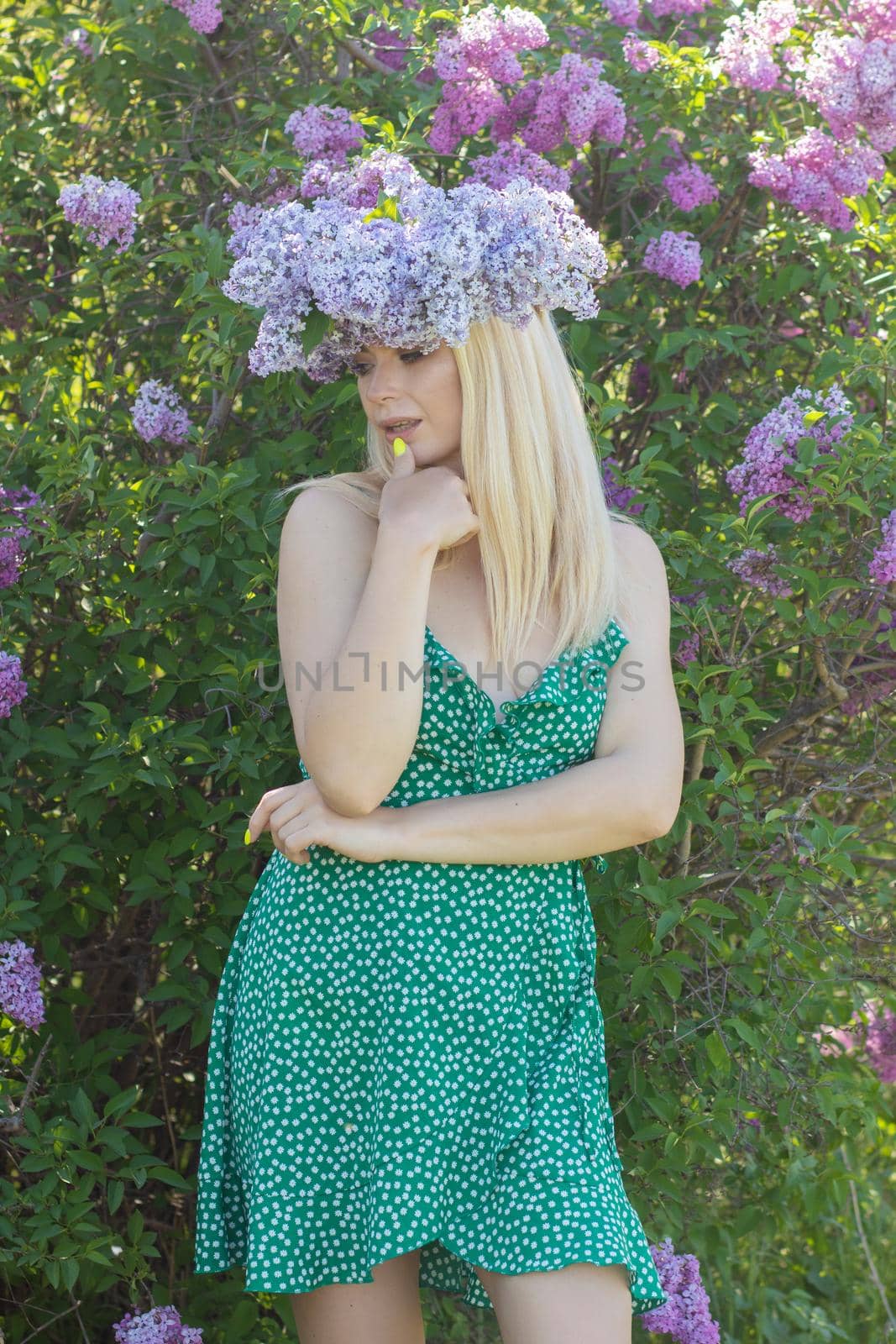 Beautiful woman in lilac Garden. Girl with lilac wreath in springtime. Gardening. Soft focus