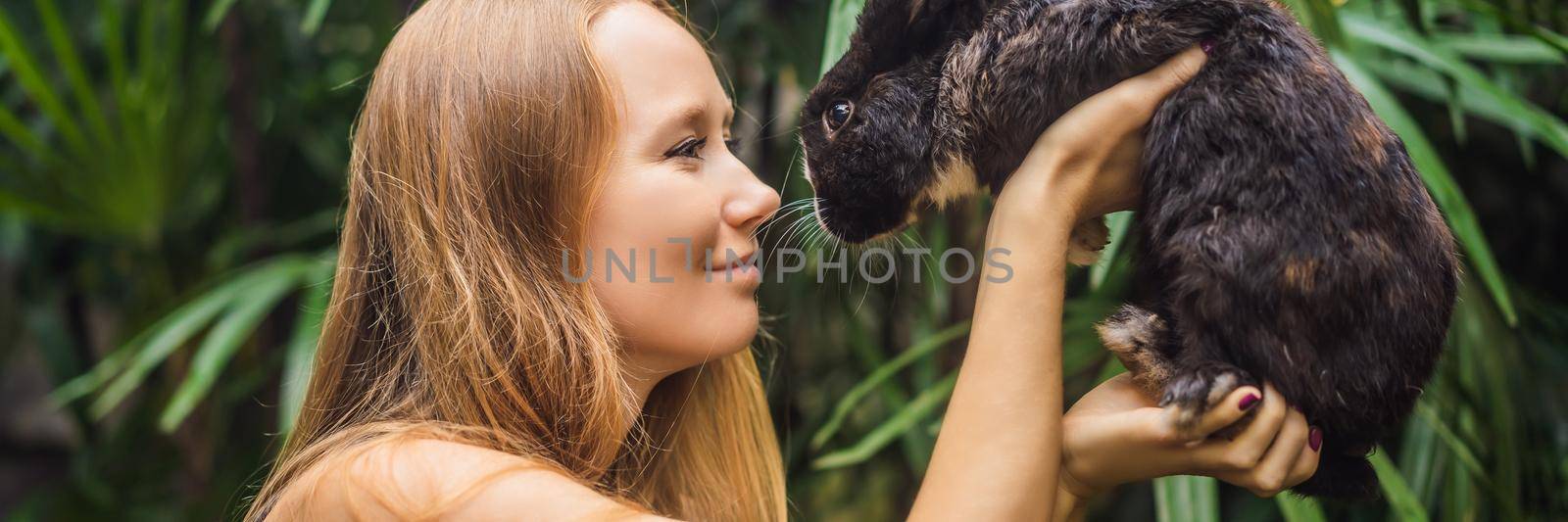Woman holding a rabbit. Cosmetics test on rabbit animal. Cruelty free and stop animal abuse concept BANNER, LONG FORMAT by galitskaya