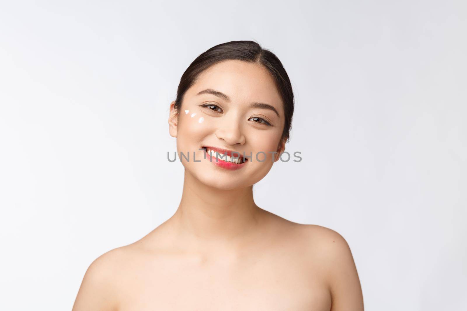 Skin care beauty woman. Beauty woman smiling applying cream. Beauty portrait of beautiful Asian Caucasian female model isolated on white