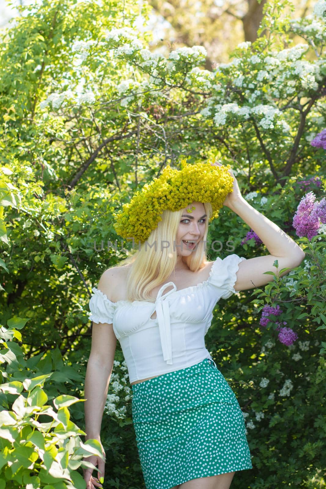 Beautiful woman in lilac Garden. Girl with yellow flower wreath in springtime. Gardening. Soft focus