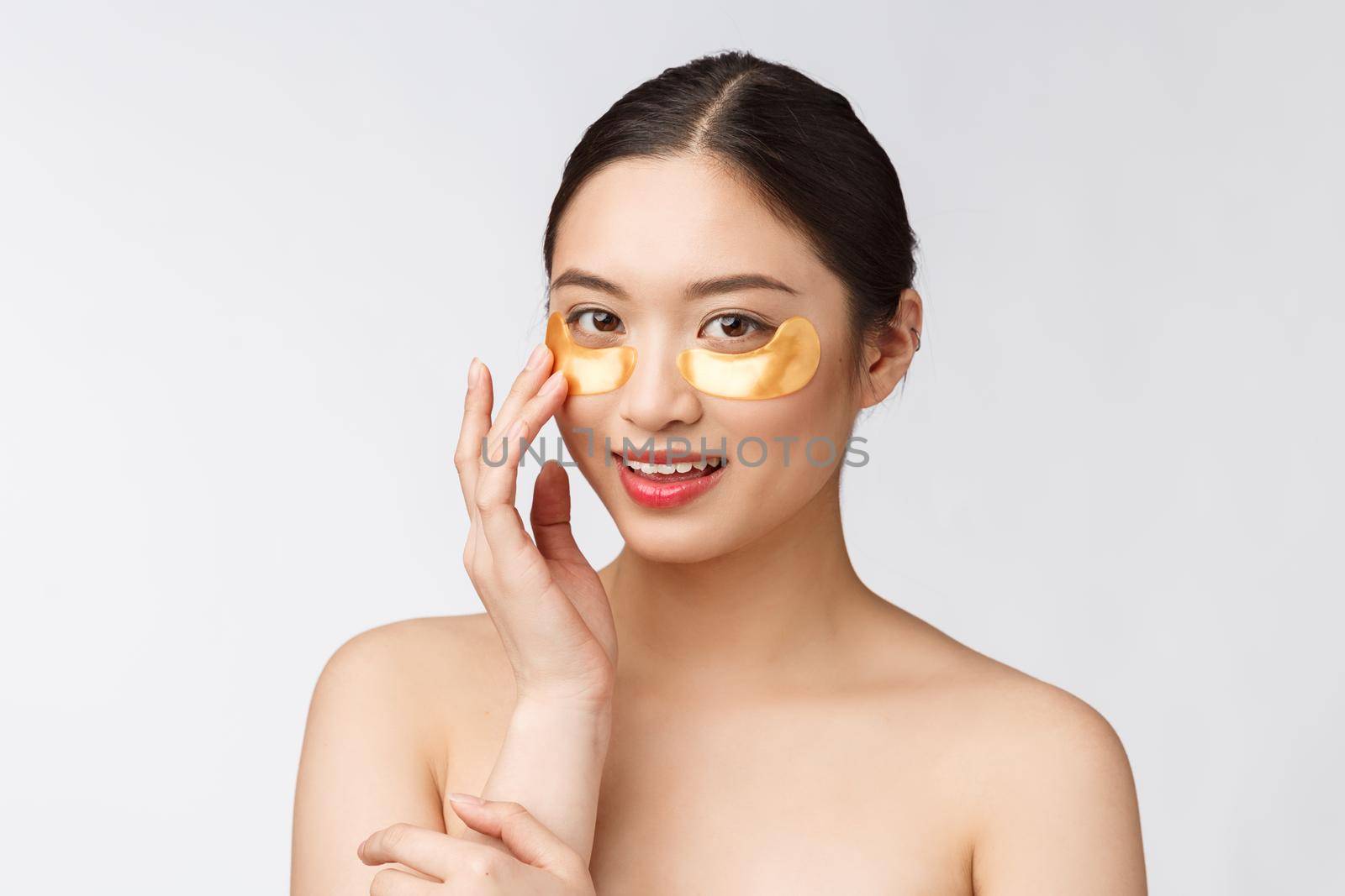 Asian beauty teenager woman care her skin with gold eye masks patches under eyes.