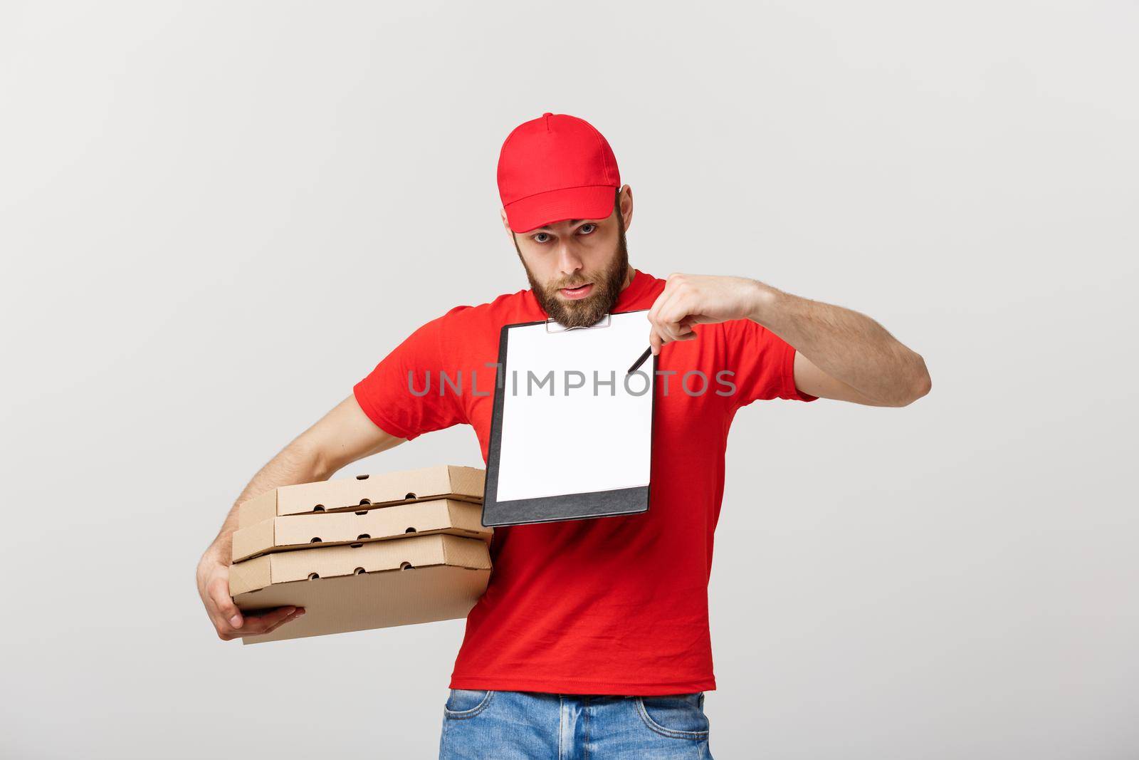 Delivery Concept: Young handsome delivery man with pizza boxes giving you a document to sign.