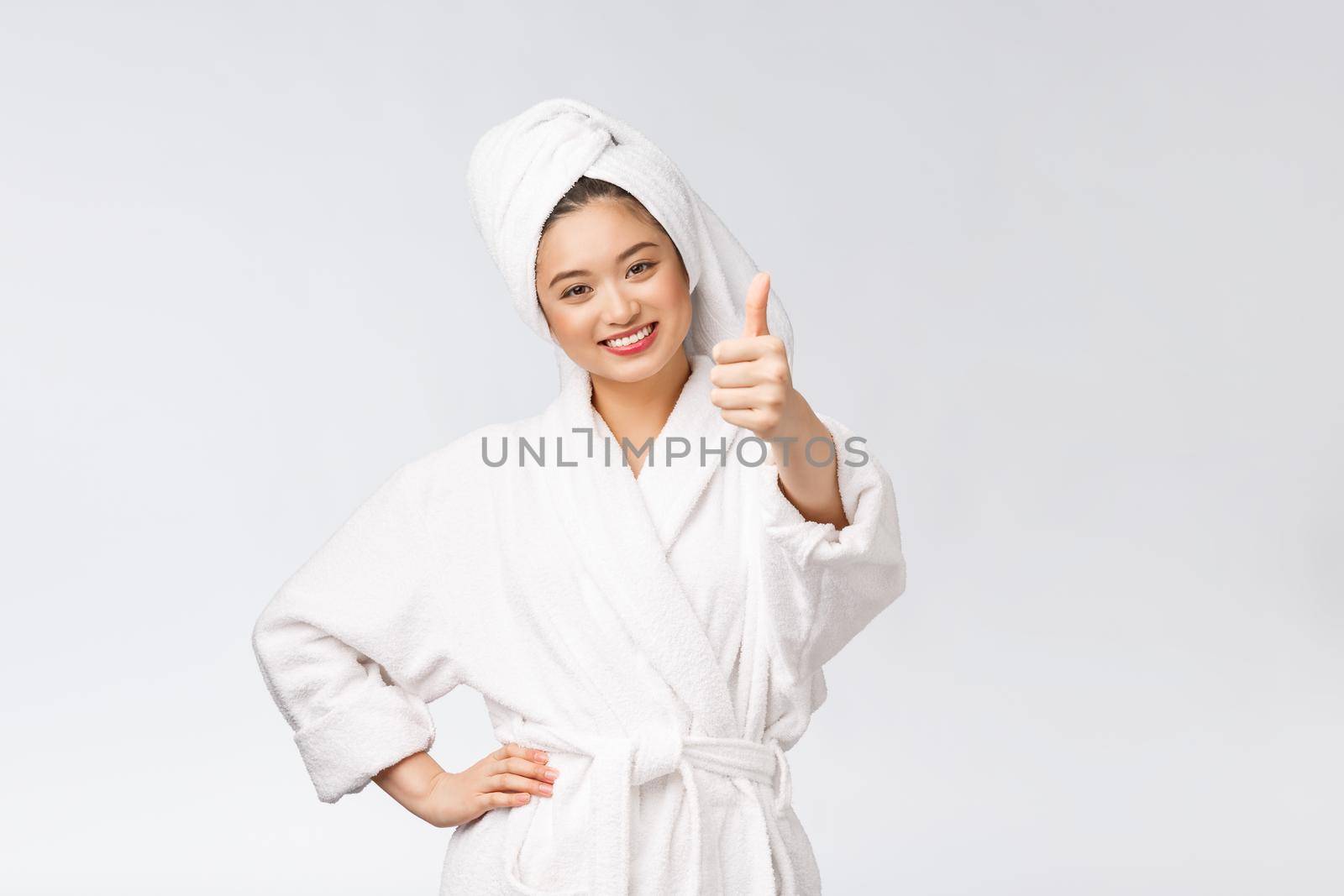 Beautiful asian woman perfect skin showing thumbs up isolated on white background