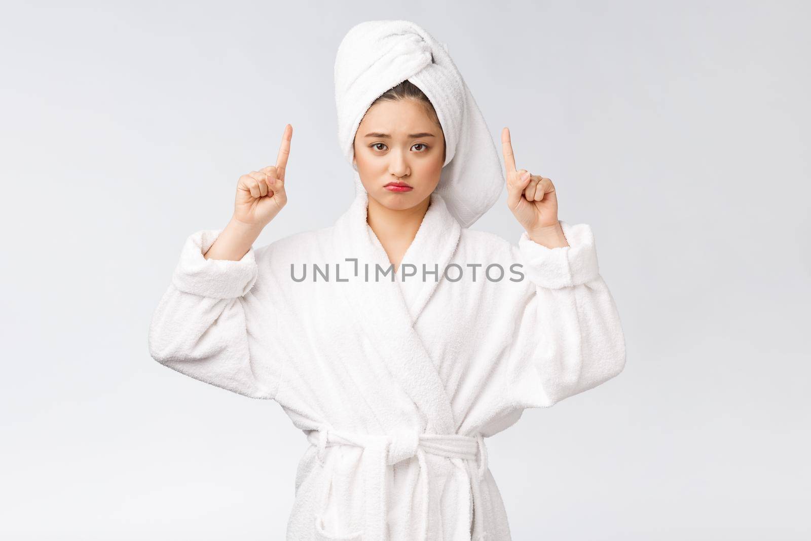 Young beautiful woman wearing shower towel after bath over isolated white background pointing with finger