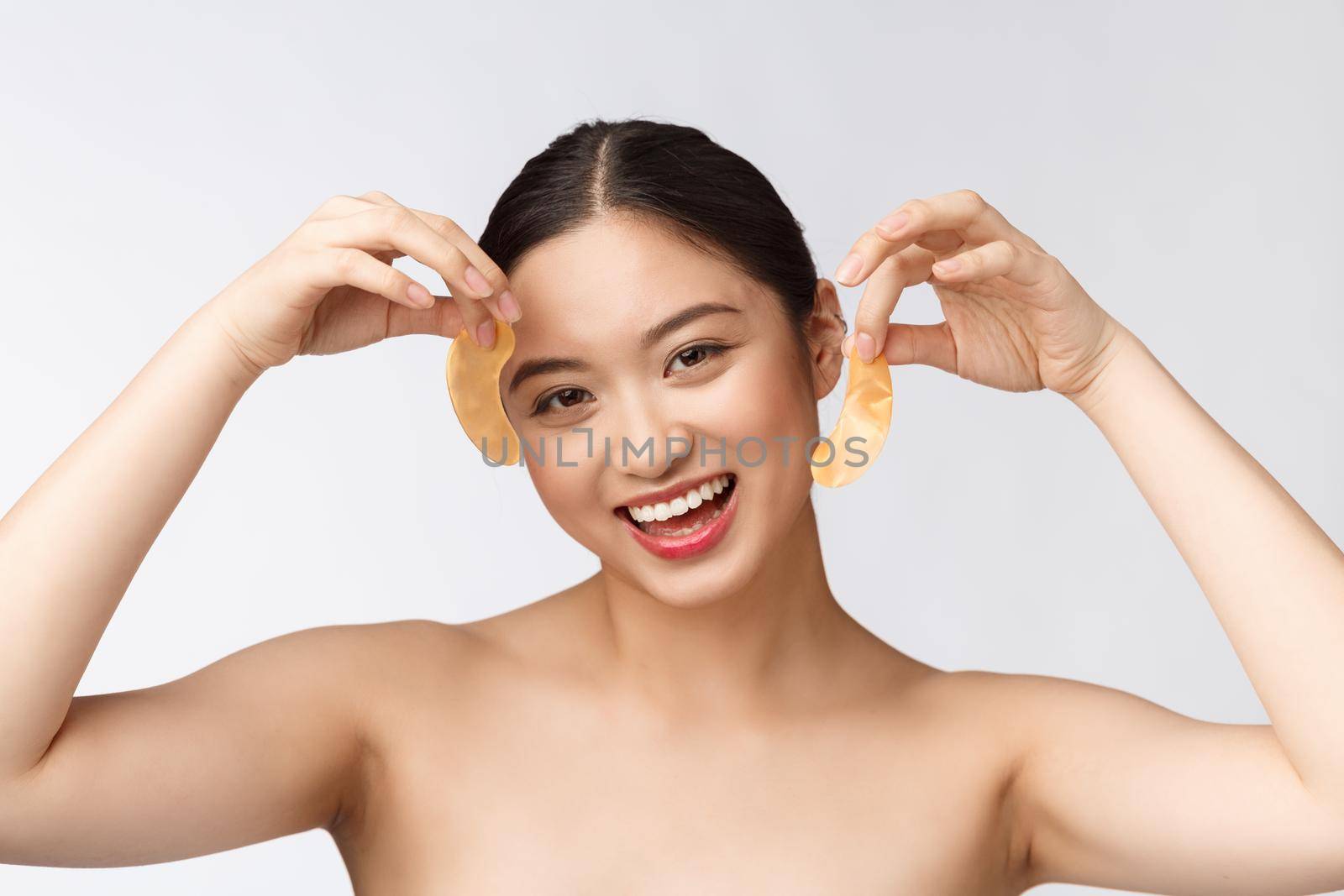 Asian beauty teenager woman care her skin with gold eye masks patches under eyes.