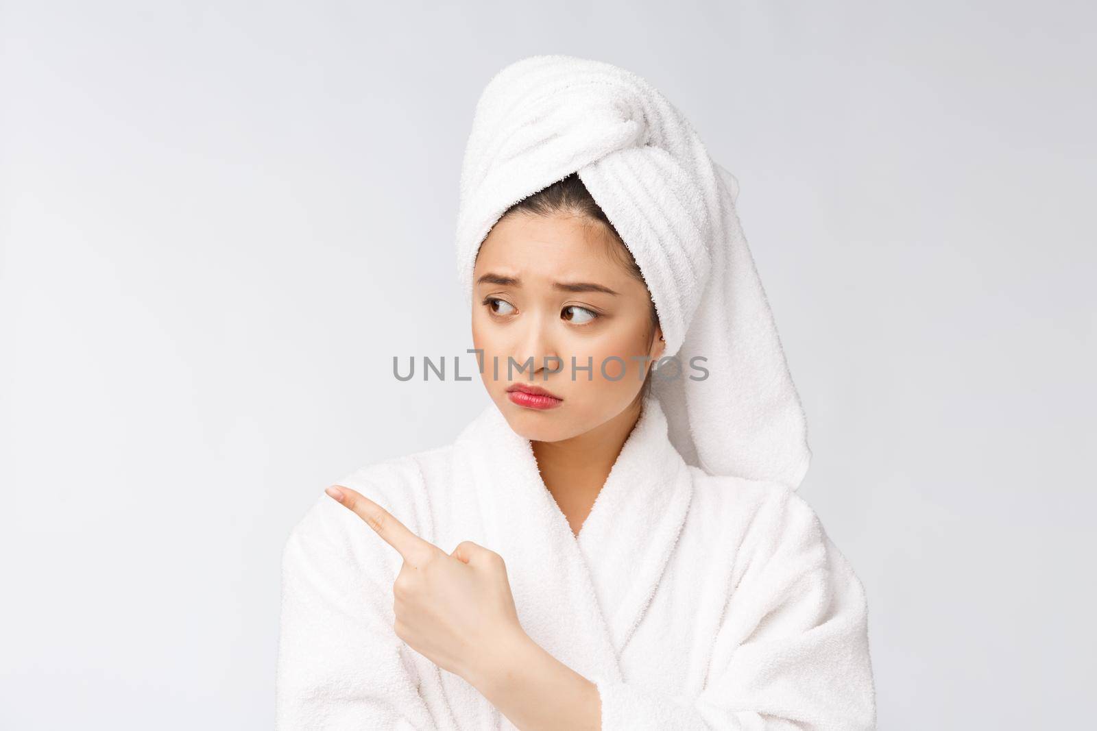 Young beautiful woman wearing shower towel after bath over isolated white background pointing with finger