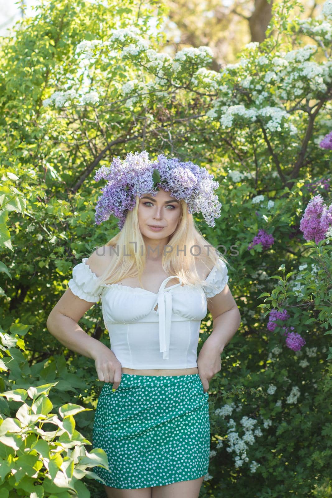 Beautiful woman in lilac Garden. Girl with lilac wreath in springtime. Gardening. Soft focus