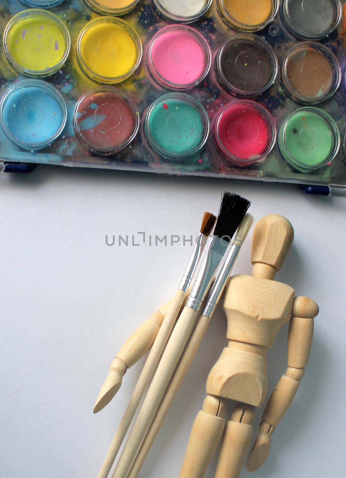 watercolor paint and a wooden mannequin