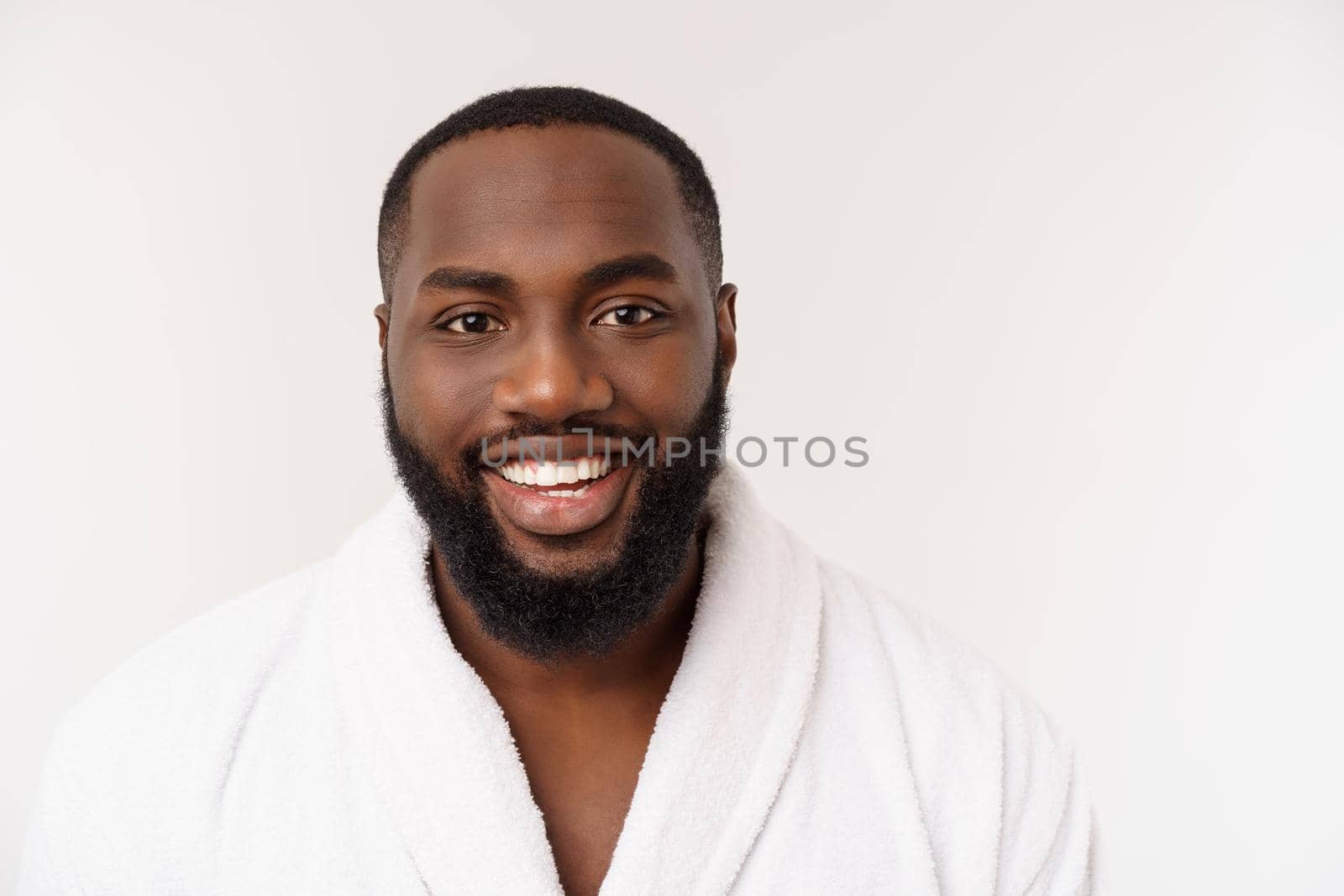 Black guy wearing a bathrobe pointing finger with surprise and happy emotion. Isolated over whtie background