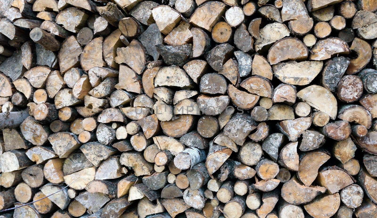 Large rural stack of firewood. Old firewood. Background.