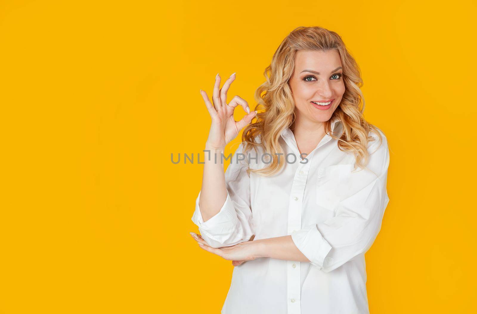 Charismatic self-confident cheerful, gorgeous adult woman, dressed in a white shirt, winking flirtatious sassy, smiling broadly, showing good, good, gesture, good mood, providing everything amazing